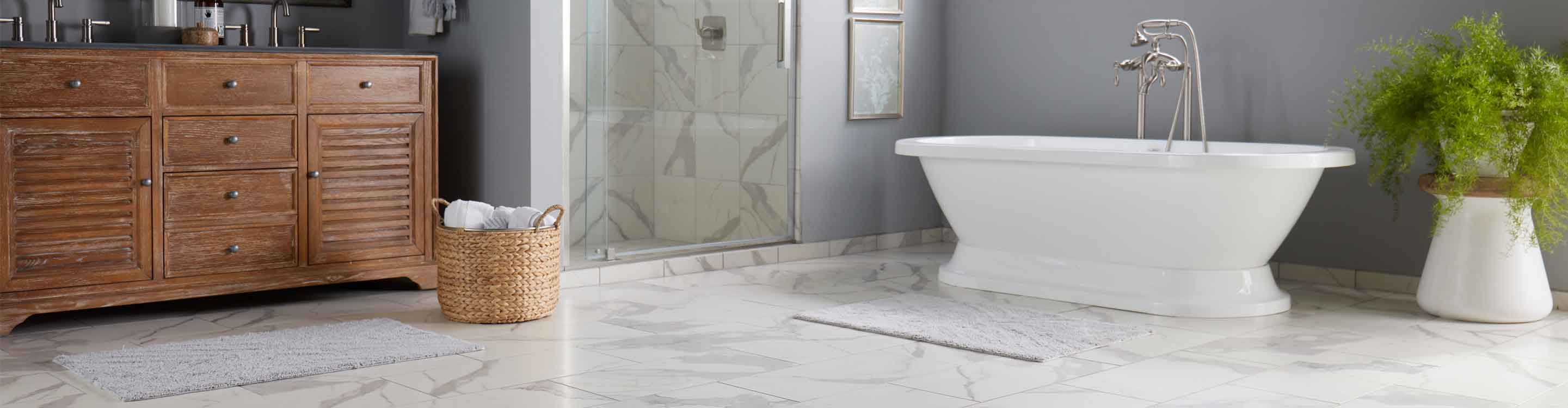 Bathroom with marble look tile flooring in Dedham, MA, and freestanding bathtub